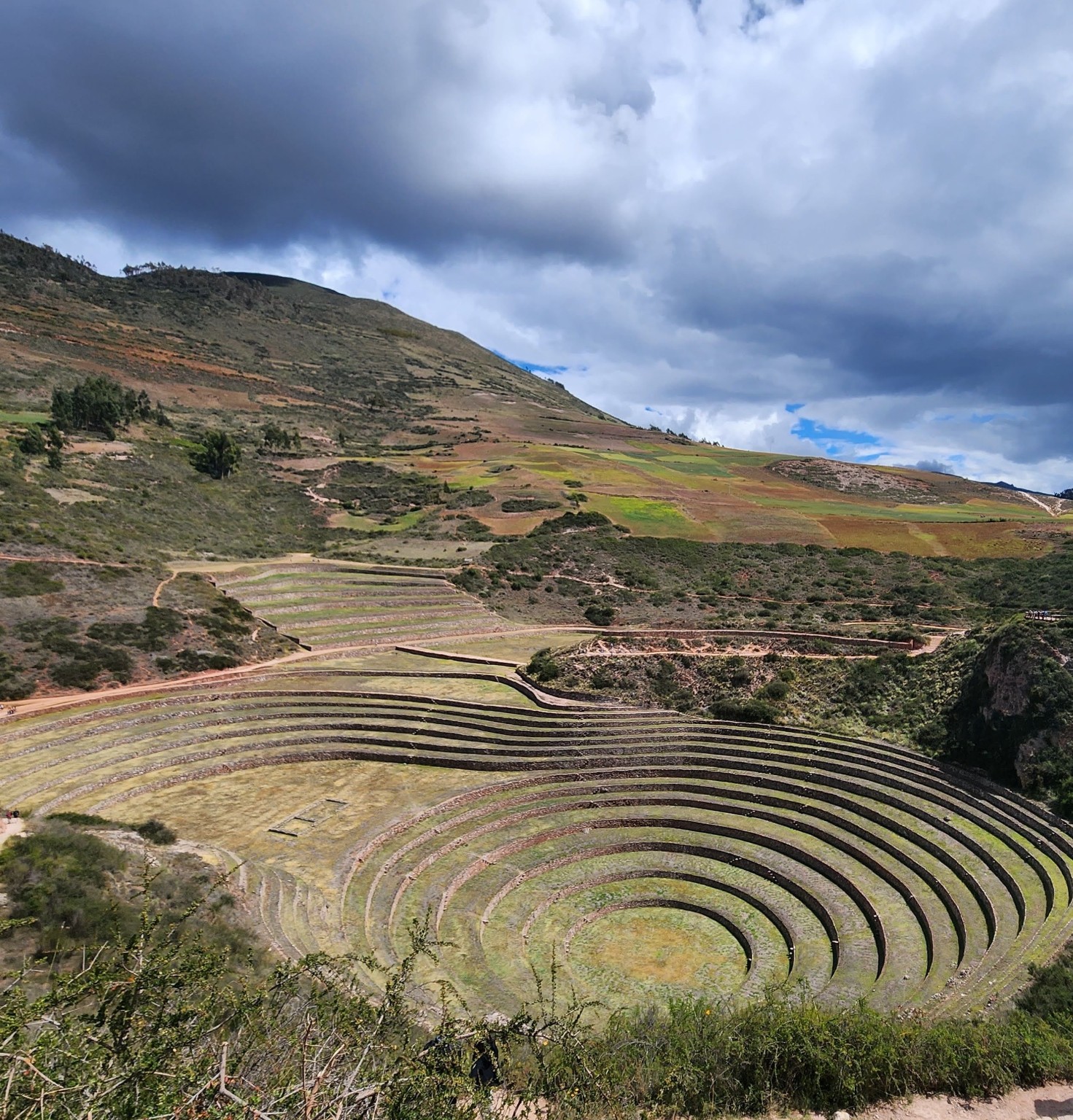 Concentric Inca agricultural terraces at Moray, Peru, under a dramatic sky